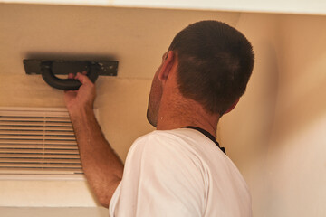 A man applying plaster on a wall with a spatula makes repairs