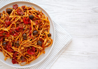 Homemade Tuna Linguine Pasta with Tomatoes, Olives and Capers on a Plate, top view. Overhead, from above, flat lay. Copy space.