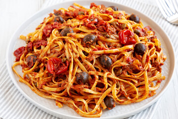 Homemade Tuna Linguine Pasta with Tomatoes, Olives and Capers on a Plate, side view.