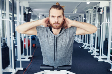 Portrait of young man doing exercises on his back in gym during his rehabilitation