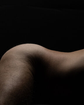 closeup nude athletic male hips and back, naked Caucasian man fitness model photo isolated on black background vertical	skin tones