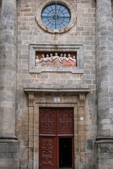 Entrance door, high columns and relief of the souls of purgatory. Facade of the Chapel of Las Ánimas. Santiago de Compostela, Galicia, Spain.