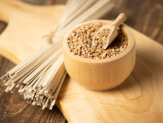 buckwheat noodles and buckwheat groats on a wooden background, rustic composition with buckwheat