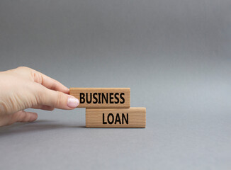 Business loan symbol. Concept words business loan on wooden blocks. Beautiful grey background. Businessman hand. Business and business loan concept. Copy space.