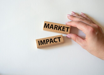 Market impact. Concept word Market impact on wooden cubes. Beautiful white background. Businessman hand. Business and Market impact concept. Copy space.