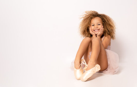 Portrait of an adorable preschool age girl playing dress up wearing a ballet tutu, isolated on white background