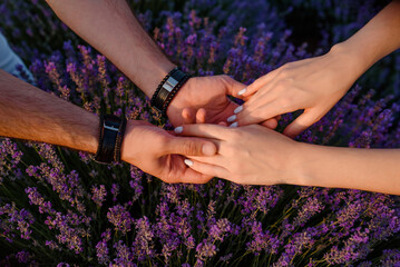 Obraz na płótnie Canvas holding hands on the lavender flowers in the lavender field.