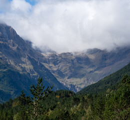 Obraz premium magnificent view of a long glacial forested valley through cloud topped Spanish Pyrenees mountains