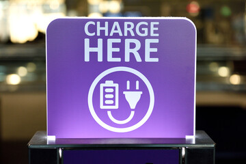 Public electrical charging station, Charge Here sign, device recharging area, power outlets