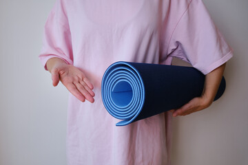 Sports girl with exercise mat prepare for yoga. Fitness yoga workout in the gym or at home. Wellness and sport concept