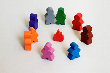 Wooden figures standing around wooden bonfire in circle. Community, team and friendship in group...