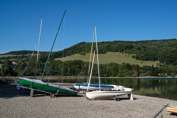 Many sailboats lined up on the beach