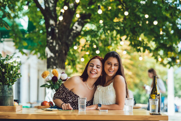 Close-up portrait of two female at summer street cafe