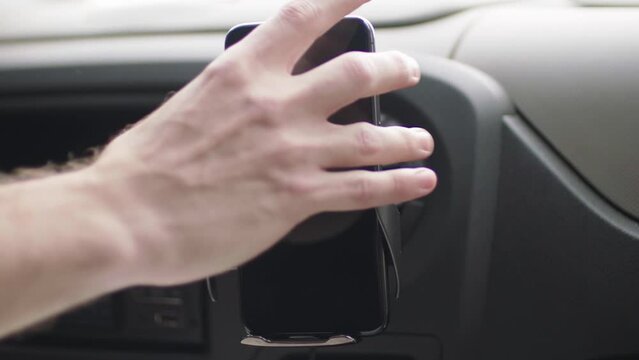 hand putting smartphone in car dashboard smartphone holder