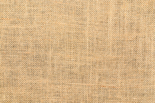 Texture background of natural burlap, close-up with a pronounced texture. Hemp fabric surface - material made from this durable natural fiber and with a uniform woven pattern