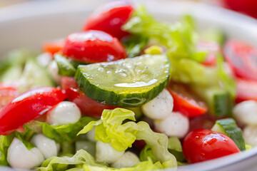 Fresh lettuce macro shot. Salad with baby mozzarella cherry leaves iceberg. Olive oil in salad. Salad with drops of oil on vegetables. Cucumber close-up. Fresh vegetables in a salad
Сucumber in 