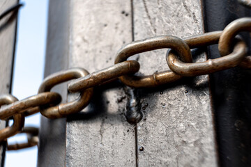 Metal chains locking a black gate with a blurred background