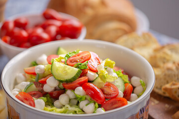 Fresh salad. Summer salad with iceberg leaves. Summer dish. Diet salad. Proper nutrition. Food on the table. Green salad. Food in the kitchen. Healthy food. Oil is poured into the salad
