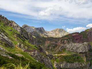 Montañas singulares en el paisaje de Somiedo en Asturias, llenas de vegetación con flores de colores morados, un cielo azul con nubes blancas en verano de 2021, España.