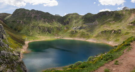 Fototapeta na wymiar Vistas panorámicas preciosas del lago del Valle en Asturias, con agua turquesa, rodeado de montañas verdes, cielo azul, nube blanca en un entorno natural relajado, verano de 2021 España.
