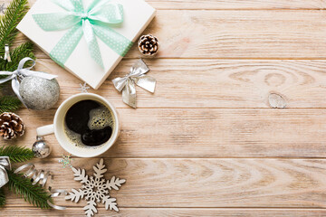 Delicious fresh festive morning coffee in a ceramic cup with little wrapped gifts, ornament and xmas toy. Cup of coffee and new year toys
