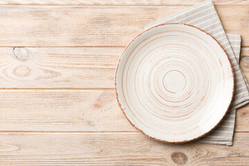 Top view on colored background empty round white plate on tablecloth for food. Empty dish on napkin with space for your design