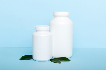 supplement pills with medicine bottle health care and medical top view. Vitamin tablets. Top view mockup bottle for pills and vitamins with green leaves, natural organic bio supplement, copy space