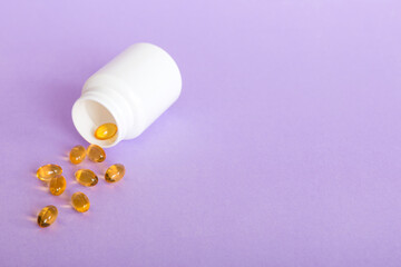 Soft gels pills with Omega-3 oil spilling out of pill bottle close-up. Gel capsules bottle white surface. Omega 3, multivitamins, Calcium, antibiotics. Health. Immunity