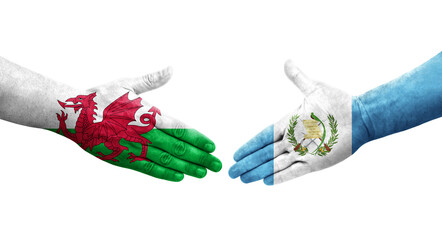 Handshake between Guatemala and Wales flags painted on hands, isolated transparent image.