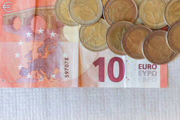 View of several 2 euro coins next to the 10 euro note
