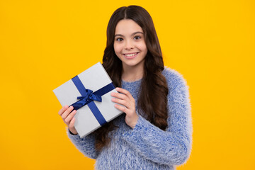 New Year or Christmas holiday gift. Happy teenager, positive and smiling emotions of teen girl. Child with gift present box on isolated studio background. Gifting for kids birthday.