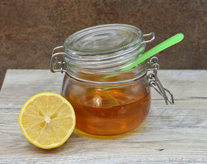 Jar of honey and lemon on a wooden table top