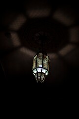Vertical shot of a vintage chandelier hanging from a ceiling in a dark