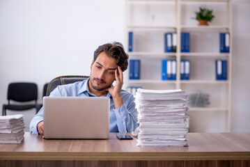 Young male employee and too much work in the office