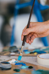 Obraz premium Artist mixes paints with a brush on a palette