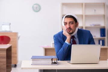Naklejka premium Young male employee suffering from toothache at workplace