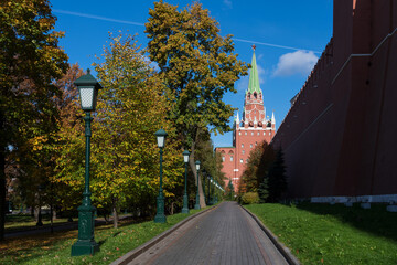 Troitskaya Tower of Moscow Kremlin rises above pedestrian road in autumn sunny day. Selective focus. Travel in Russia theme.