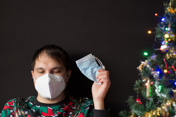 Man with protection mask near Christmas tree