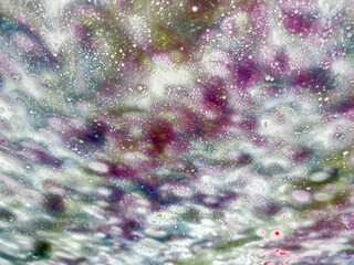Texture background of abstract designs from water and colorful soap suds on a vehicle windshield in an automated car wash - obrazy, fototapety, plakaty