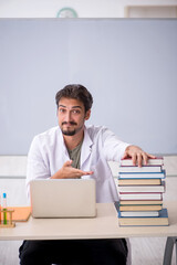 Young male chemist teacher in front of whiteboard