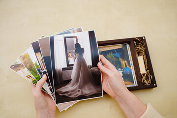 printed wedding photos in the hands and in a wooden box with a flash drive.  - Powered by Adobe