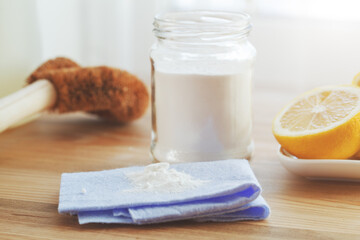 Lemon, bamboo brush and baking soda on kitchen table. Eco friendly cleaning products. Zero waste sustainable lifestyle