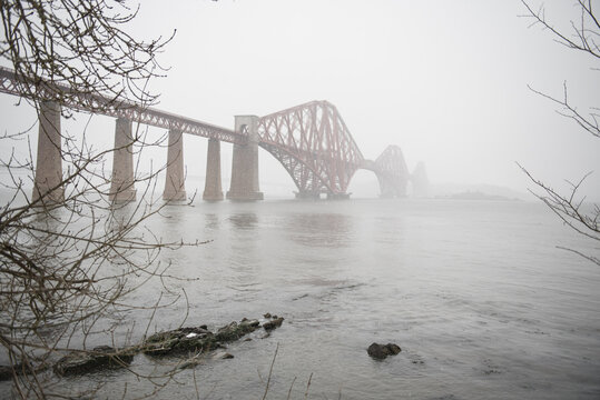 View of the George IV Bridge Rail Bridge from South Queensferry on the Firth of Forth in an Winter day in Edinburgh, Scotland, UK, in a misty day with snowy blizzards