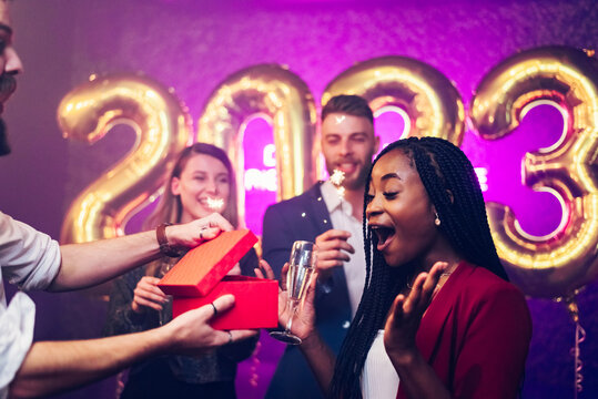 Diverse couple exchanging gifts while on the birthday party or new years eve