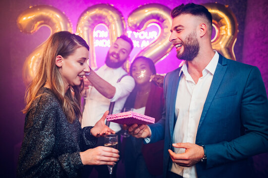Couple exchanging gifts for birthday party or new years eve in the club