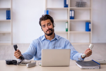 Young male call center operator working at his desk