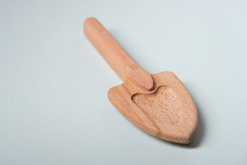 A small wooden shovel, a children's toy on a blue background