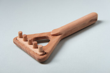Small wooden rake, children's toy on a blue background