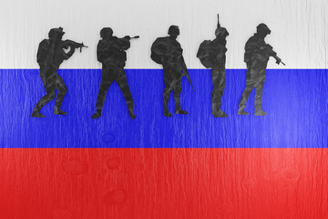 Paper cutting of silhouettes of solders on a wooden table printed with the national flag of Russia. Illustration of the concept of Russian military actions, shortage of soldiers and conscription