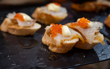Typical snack of Basque Country and Navarre, pinchos or pinxtos served in bar, small slices of bread upon which ingredient or mixture of ingredients is placed, San Sebastian, Spain